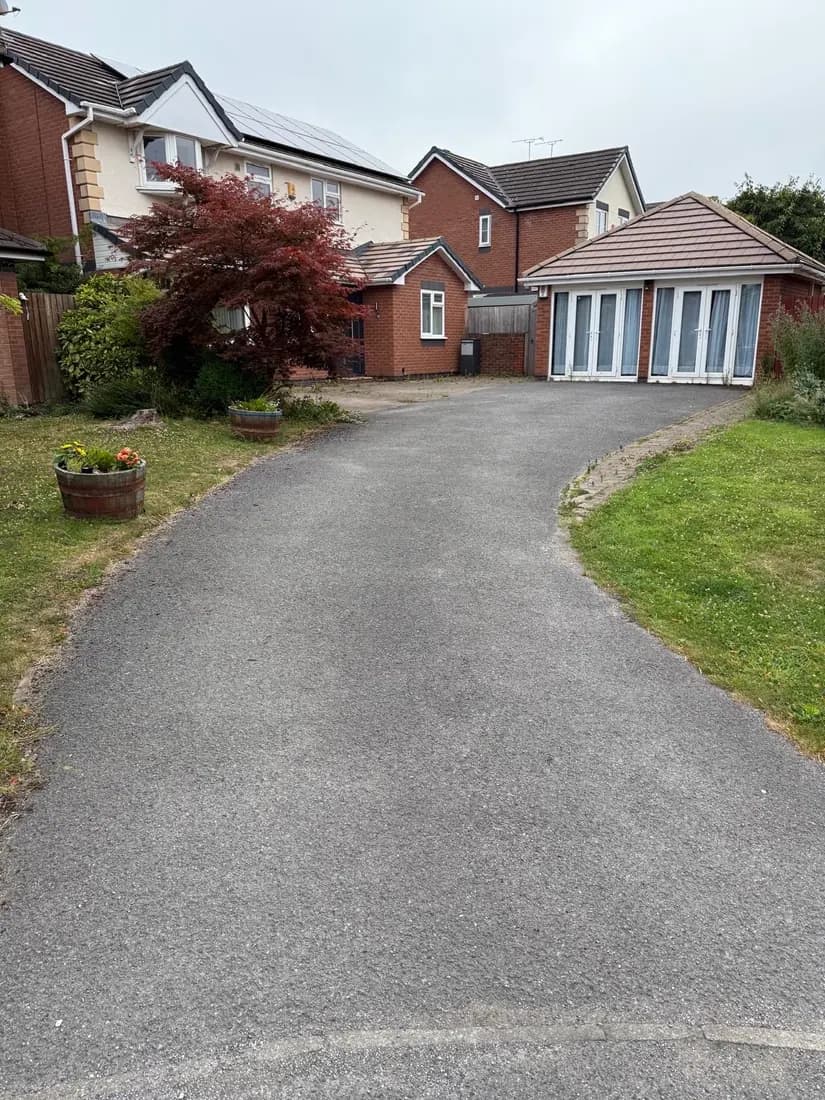Before: the original worn tarmac driveway sweeping between two lawns up to the garage