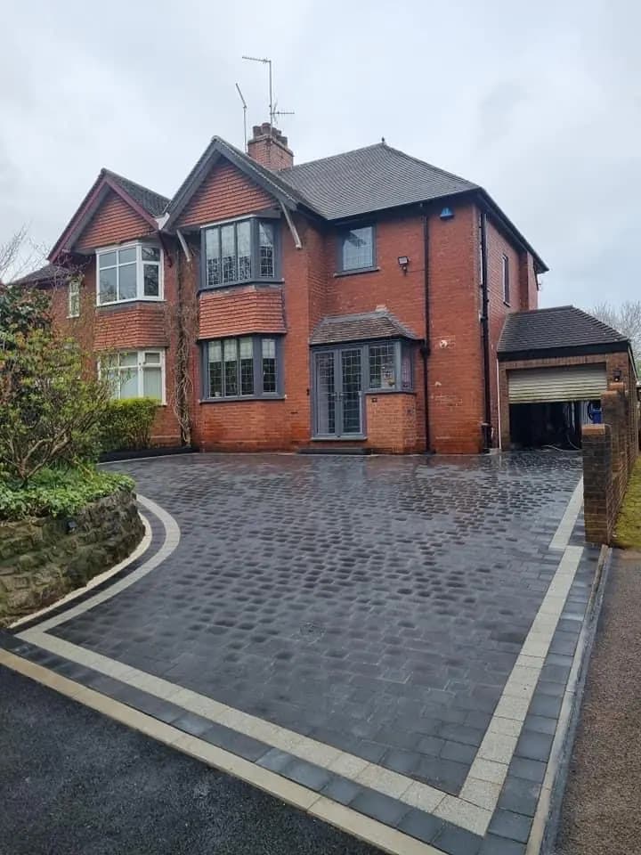 Block paving driveway with a cream inlay border sweeping toward a garage at a Cheshire Golden Triangle home
