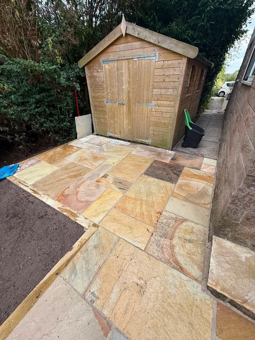 Indian sandstone path running down a long rear garden to a timber shed