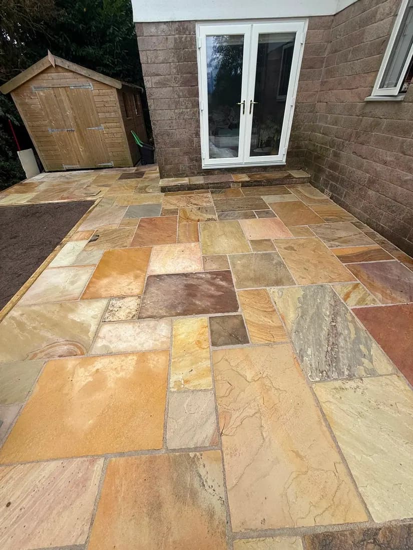 Indian sandstone patio laid in a random rectangular pattern
