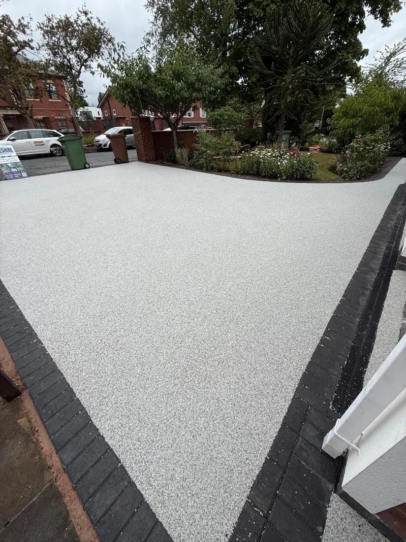 Resin bound driveway finished against a dark block paving border