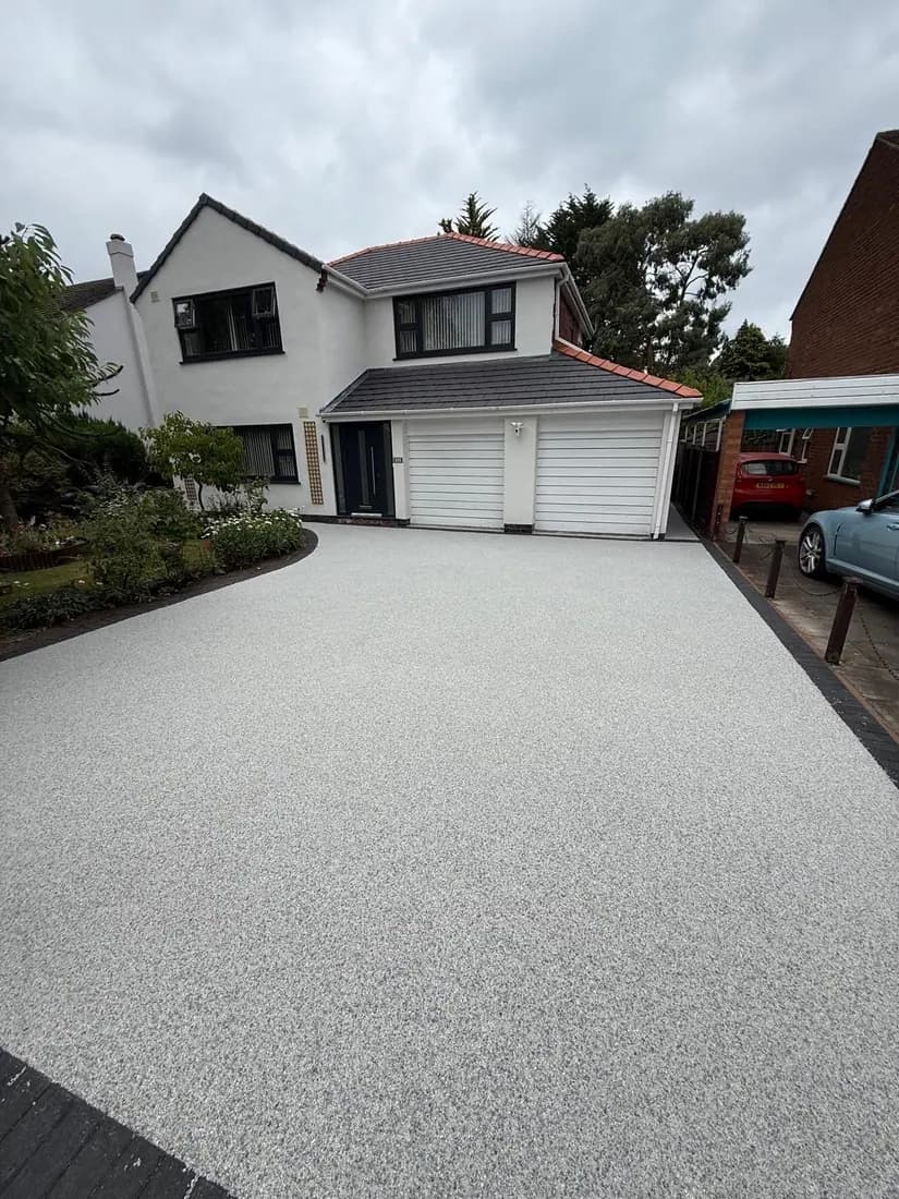 Pale resin bound driveway laid across the full frontage of a detached house