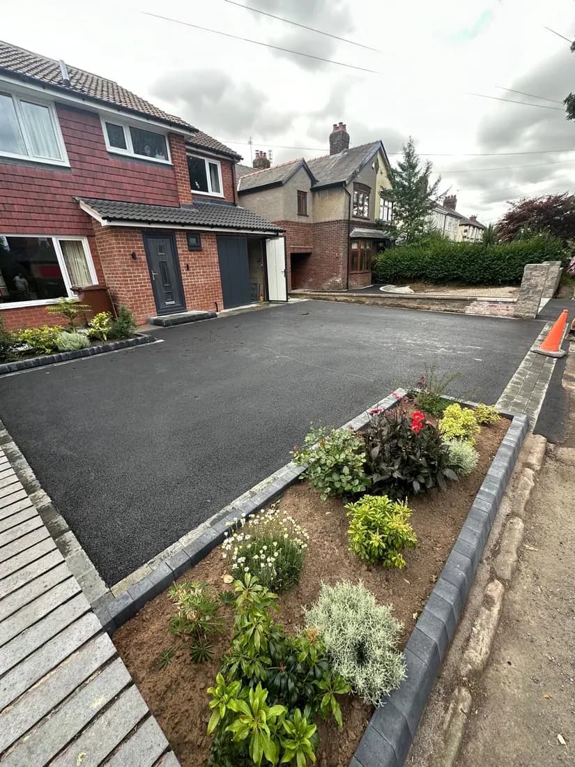 Tarmac driveway finished around an established flower bed and block edge in Stockport