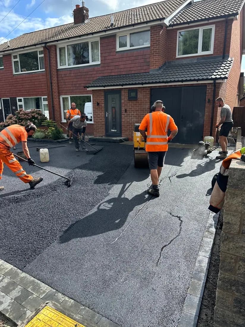 The Cheshire Paving Solutions team in hi-vis uniform laying a new tarmac driveway
